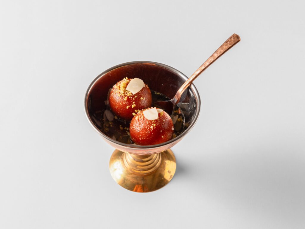 Gulab jamun i en skål med ske.