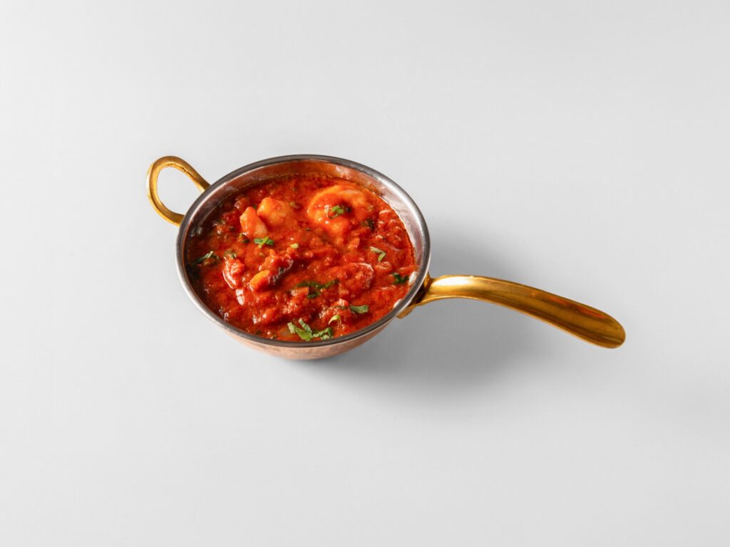 Traditionel indisk curry i kobbergryde med håndtag