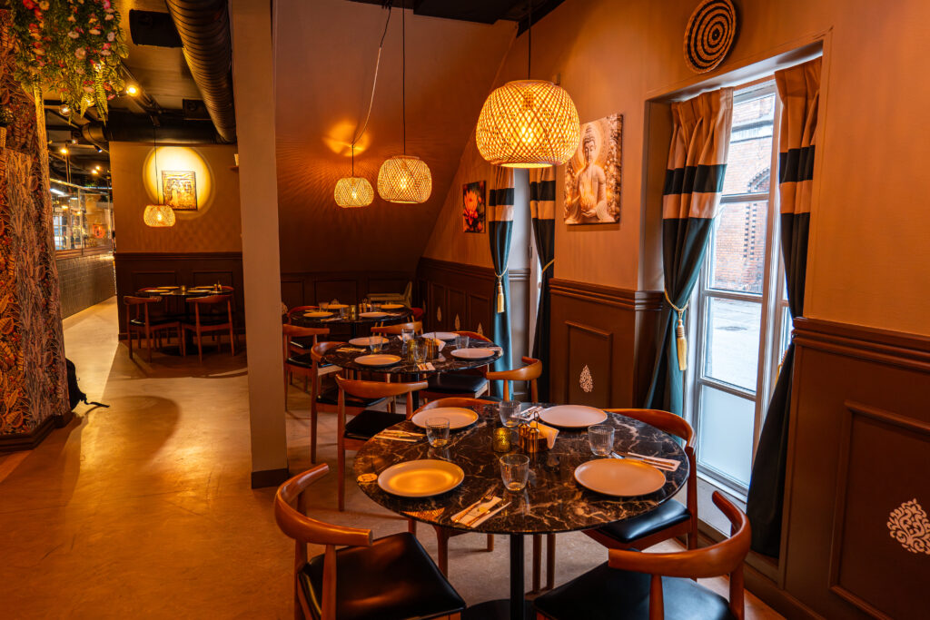 Hyggelig restaurant med dækkede borde og varme lamper.