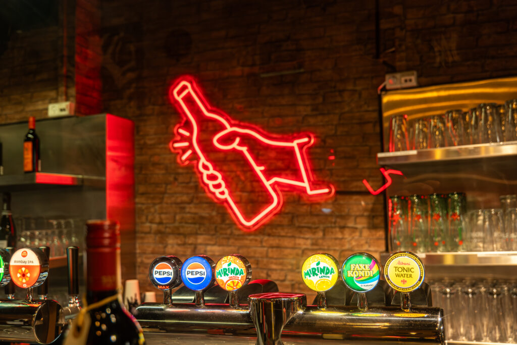 Bar med ølhaner og neonlys flaske skilte