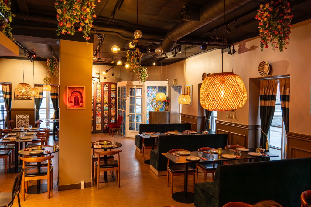 Moderne restaurantinteriør med varm belysning og blomsterdekorationer.