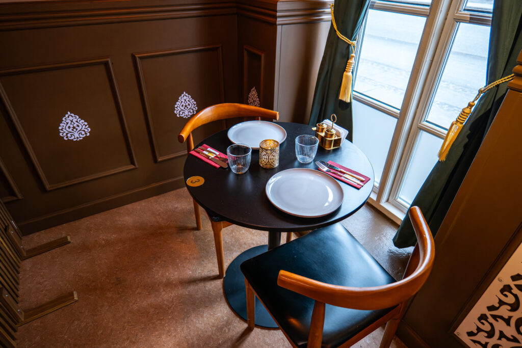 Dækket bord til to personer ved vindue